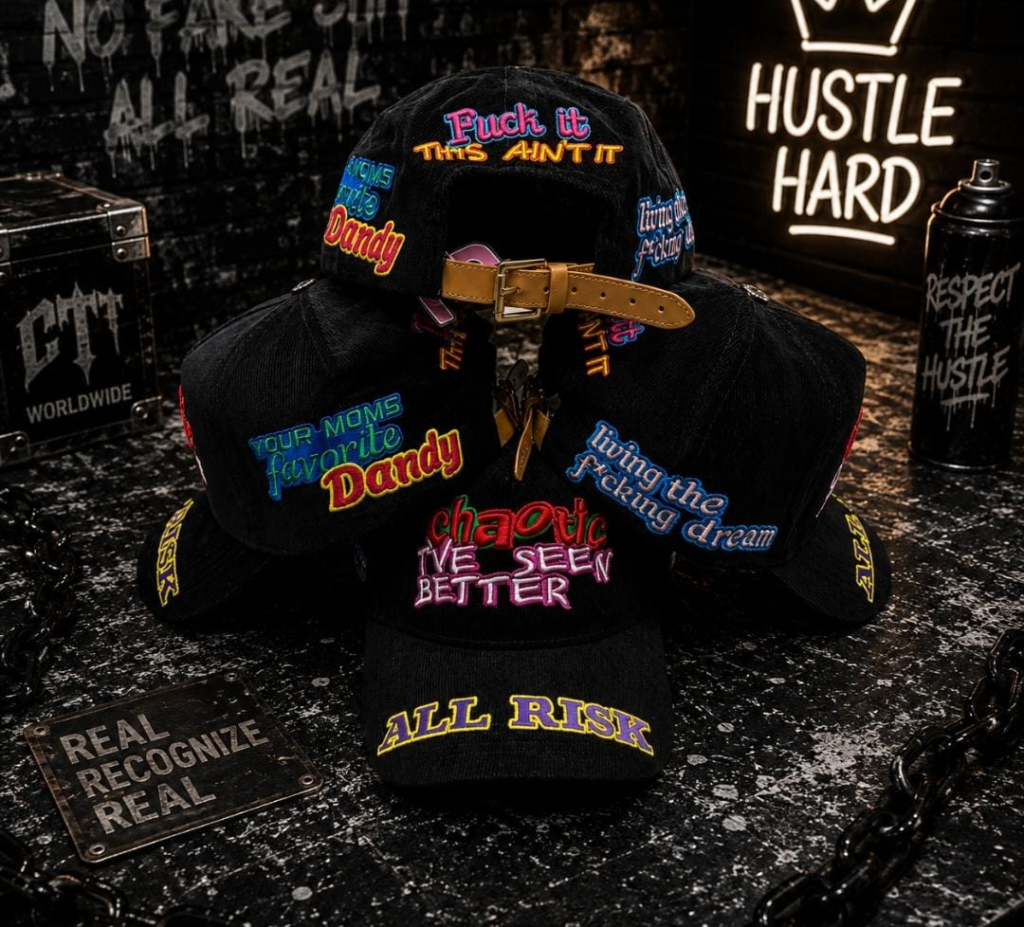 Black cap with neon embroidered slogans including All Risk, Your Moms Favorite Dandy and Hustle Hard.